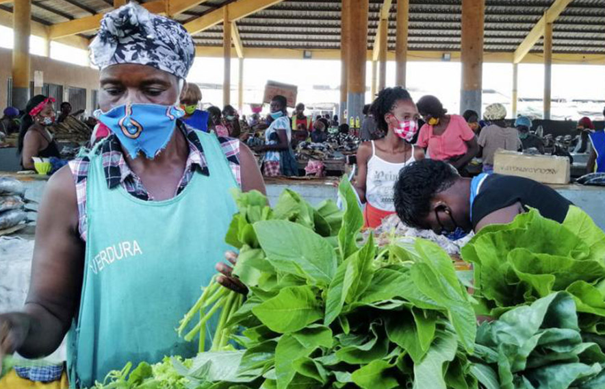 Woman sorting through produce at a market place